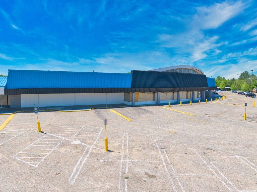 A shopping center exterior featuring a modern design with large windows and a welcoming entrance at Normendale Shopping Cente