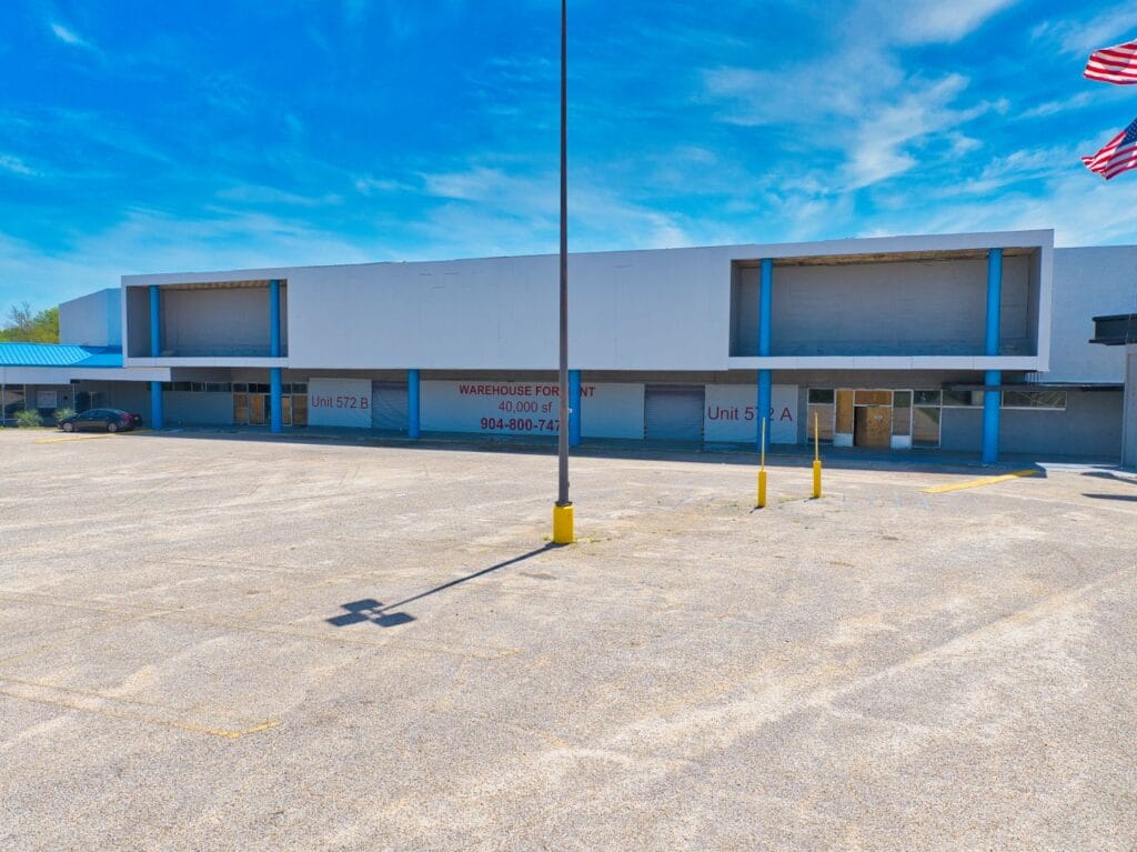 Exterior view of Normendale Shopping Center showcasing storefronts and parking area, emphasizing the vibrant shopping environ