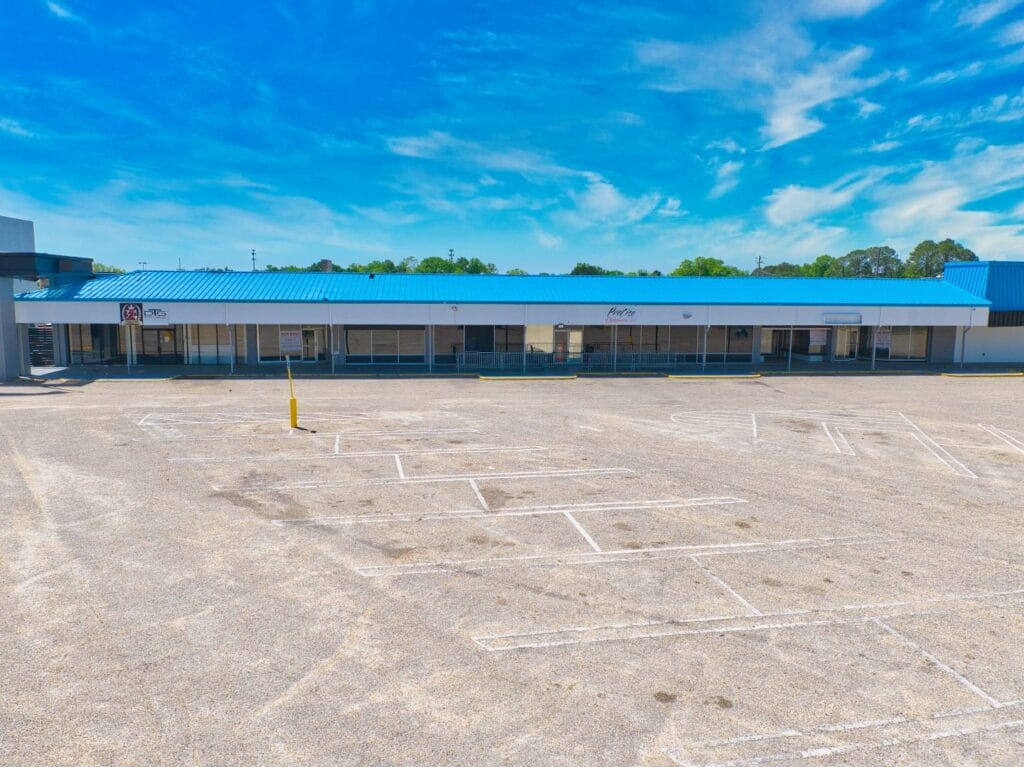 Exterior view of Normendale Shopping Center showcasing storefronts and parking area, highlighting the vibrant shopping enviro