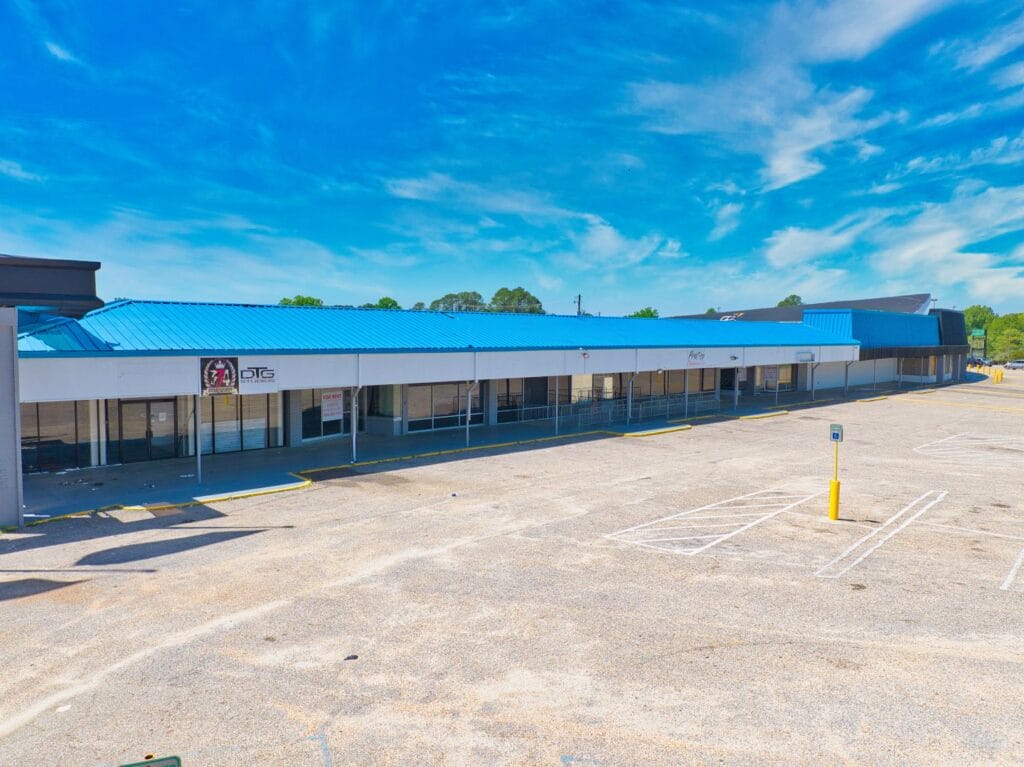 Exterior view of Normendale Shopping Center featuring storefronts and a parking area, showcasing a vibrant shopping environme