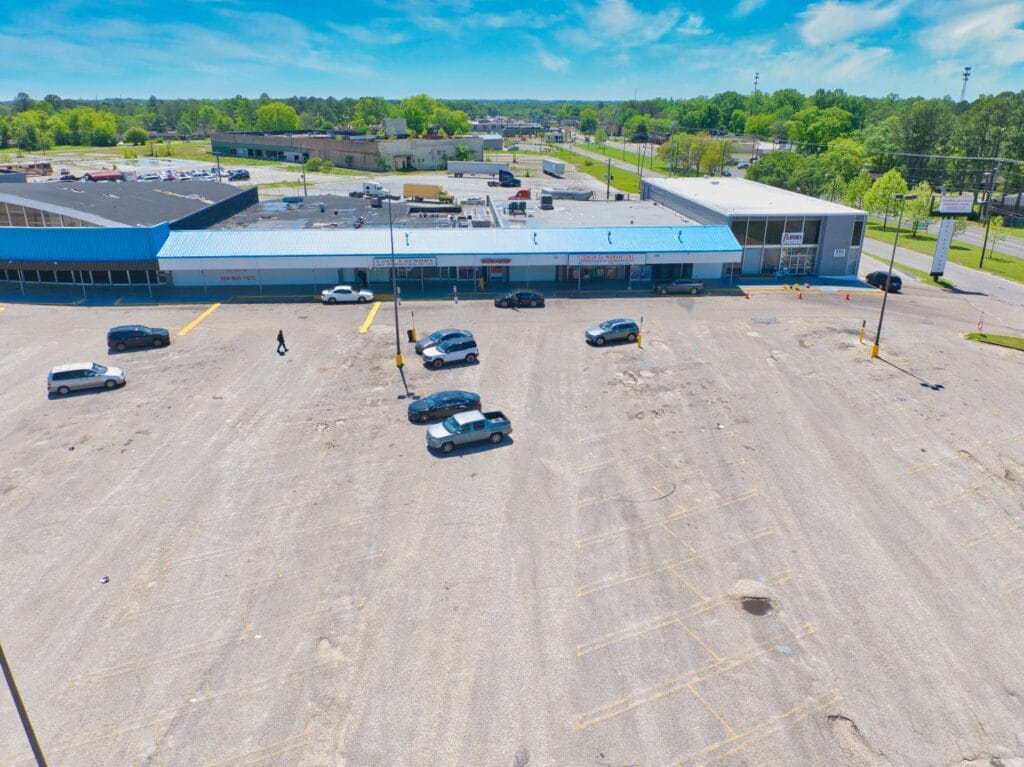 Exterior view of Normendale Shopping Center showcasing storefronts and signage in a vibrant commercial area.