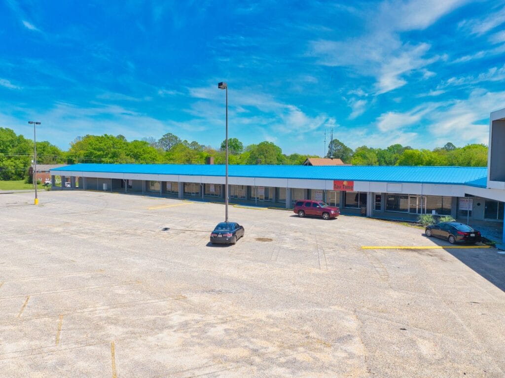 A view of Normendale Shopping Center showcasing various storefronts and parking area, emphasizing retail opportunities.