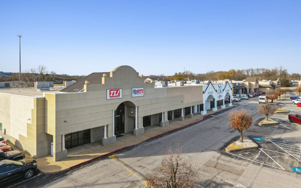 Exterior view of City Mall Retail Center, showcasing storefronts and a clear sky, ideal for shopping.