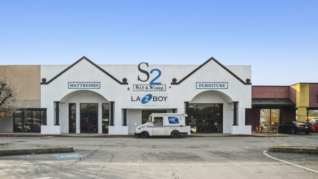 Exterior view of 407 N Arkansas Ave, a retail center in Russellville, AR, showcasing its storefronts and signage.