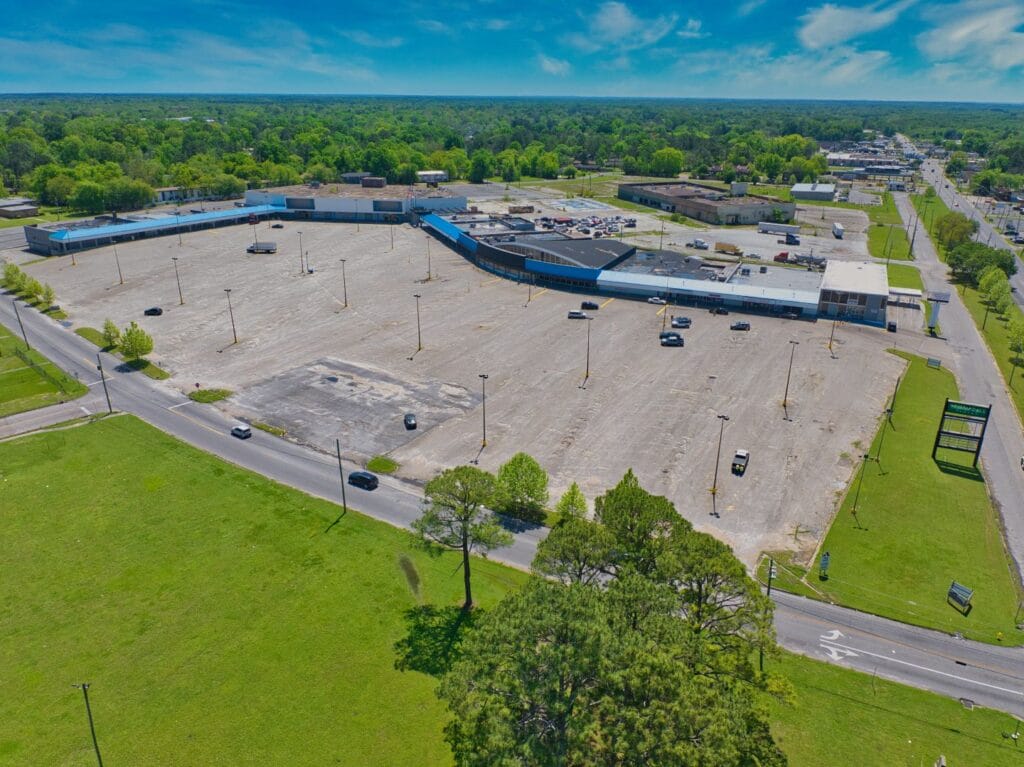 A shopping center exterior featuring multiple storefronts and a clear blue sky, ideal for exploring retail options.