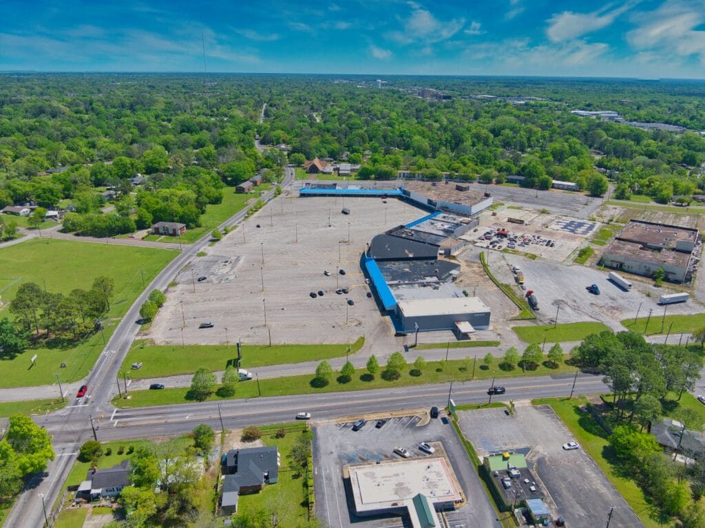 Exterior view of Normendale Shopping Center showcasing storefronts and a clear blue sky.