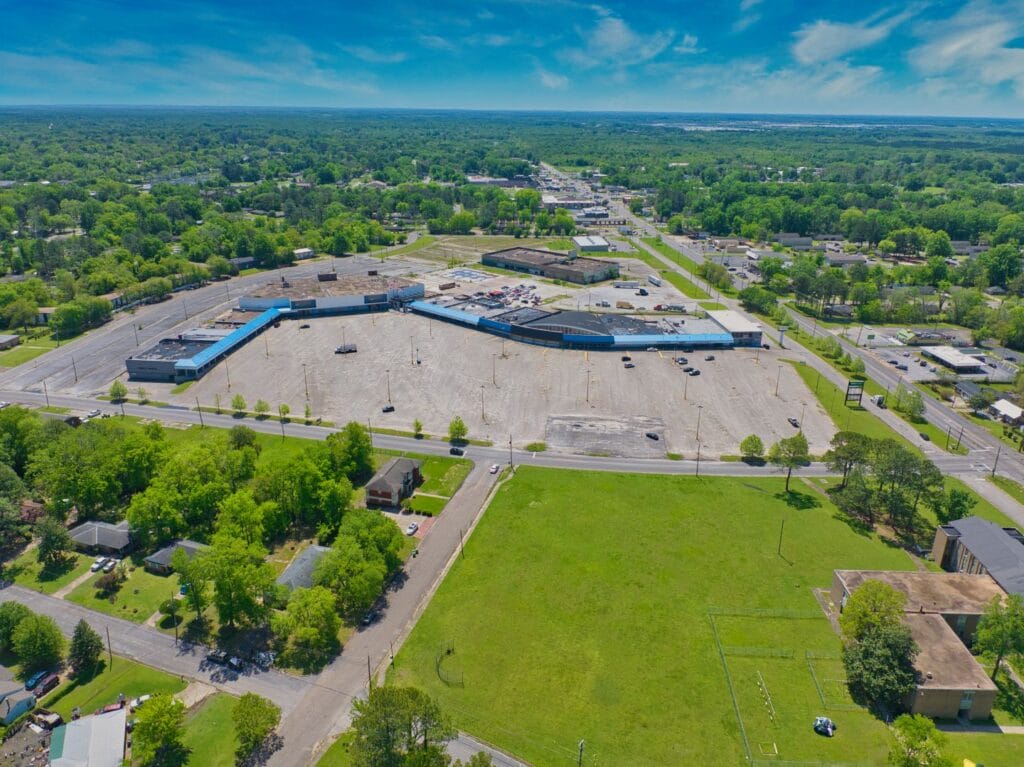 Exterior view of Normendale Shopping Center showcasing storefronts and parking area, emphasizing its commercial appeal.