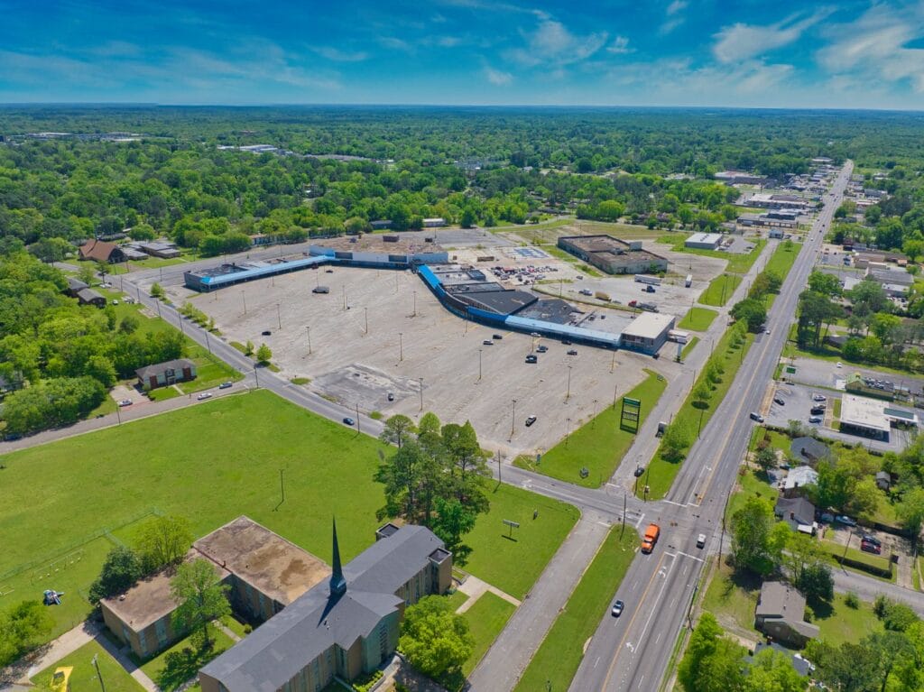 Exterior view of Normendale Shopping Center showing storefronts and parking area, highlighting retail opportunities.