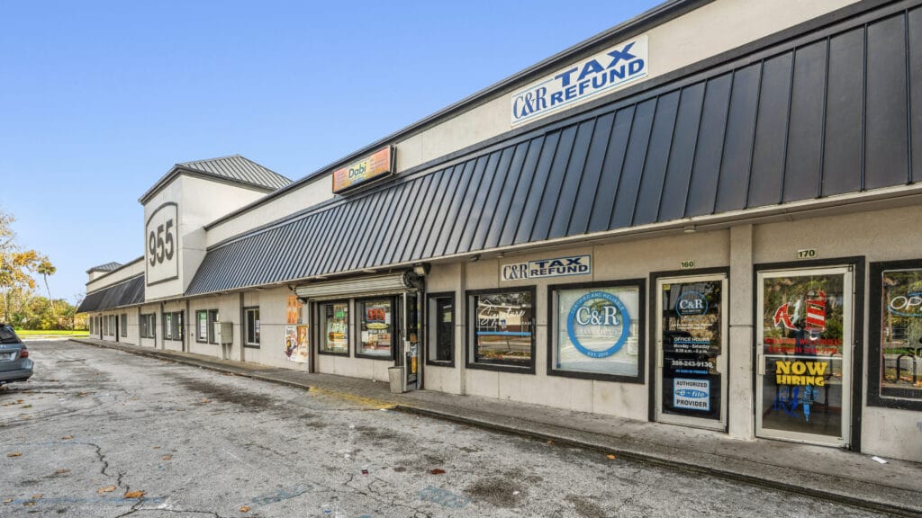 Exterior view of 955 Orange Ave in Daytona Beach, showcasing the shopping center's architecture and signage.