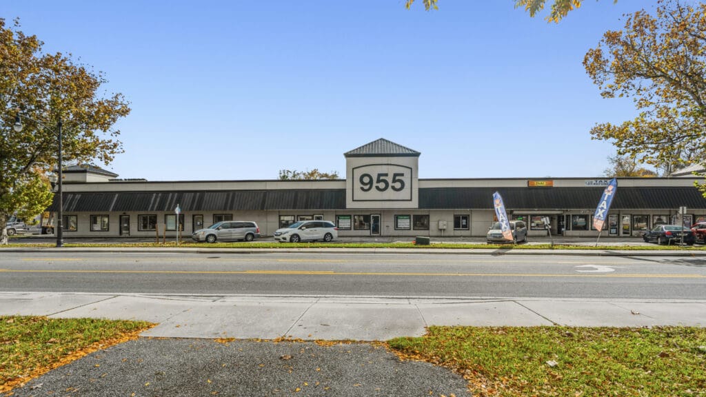 Exterior view of 955 Orange Ave, Daytona Beach, showcasing the shopping center's signage and surrounding landscape.