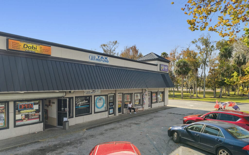 Exterior view of the Orange Shopping Center in Daytona Beach, showcasing its modern architecture and storefronts.