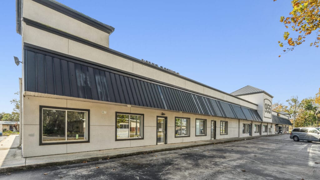 Exterior view of the 955 Orange shopping center showcasing modern architecture and storefronts.