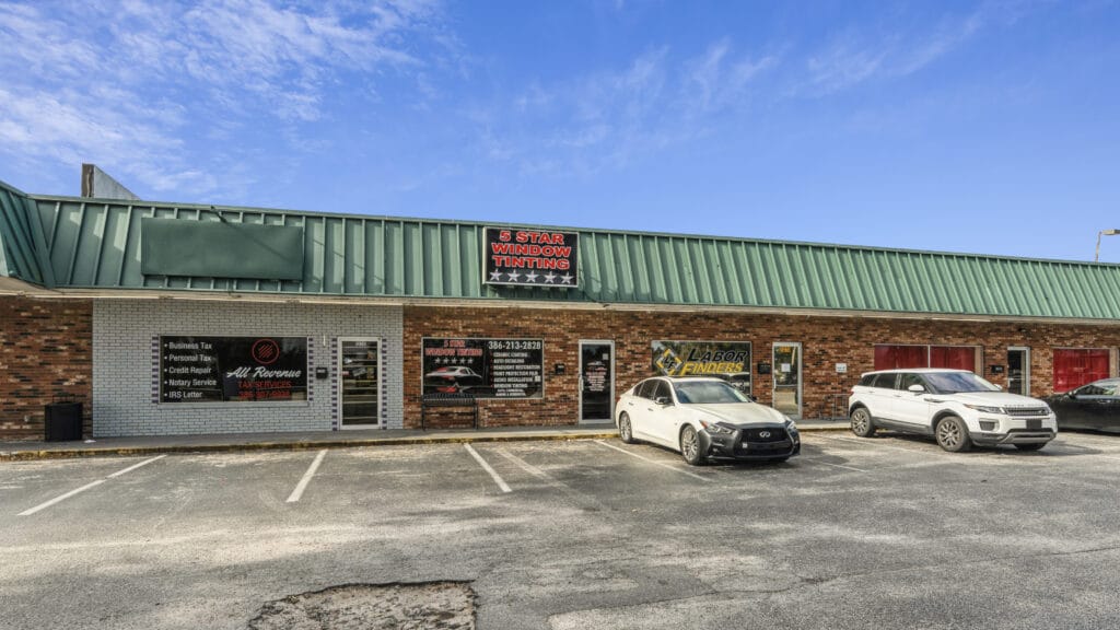 Exterior view of 1210 N Nova Rd in Daytona Beach, showcasing a modern building with large windows and landscaping.
