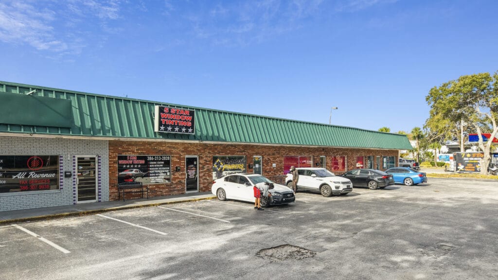 A commercial property at 1210 N Nova Rd, Daytona Beach, FL, showcasing a modern building with ample parking.