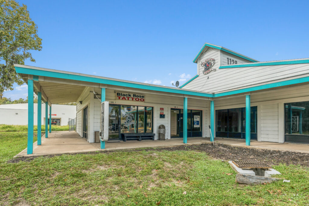 Exterior view of a commercial property at 1128 Beville Rd, Daytona Beach, showcasing its architecture and surroundings.