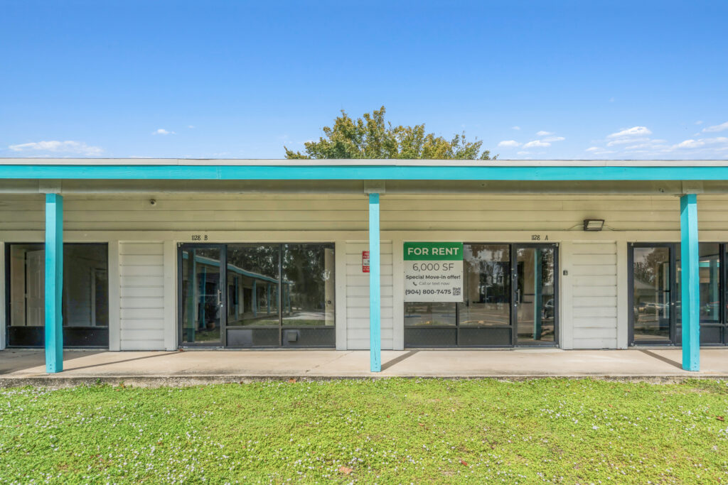 Exterior view of a commercial property at 1128 Beville Rd, Daytona Beach, showcasing a modern facade and surrounding landscap