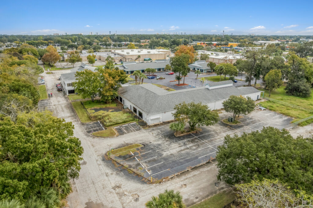 A spacious commercial property at 1128 Beville Rd, Daytona Beach, featuring a modern facade and ample parking.