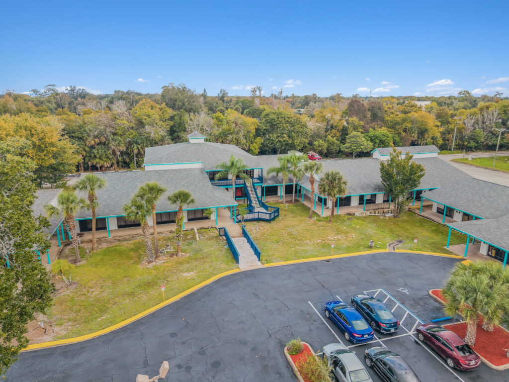 A modern commercial building exterior with large windows and a welcoming entrance, located at 1128 Beville Rd, Daytona Beach.