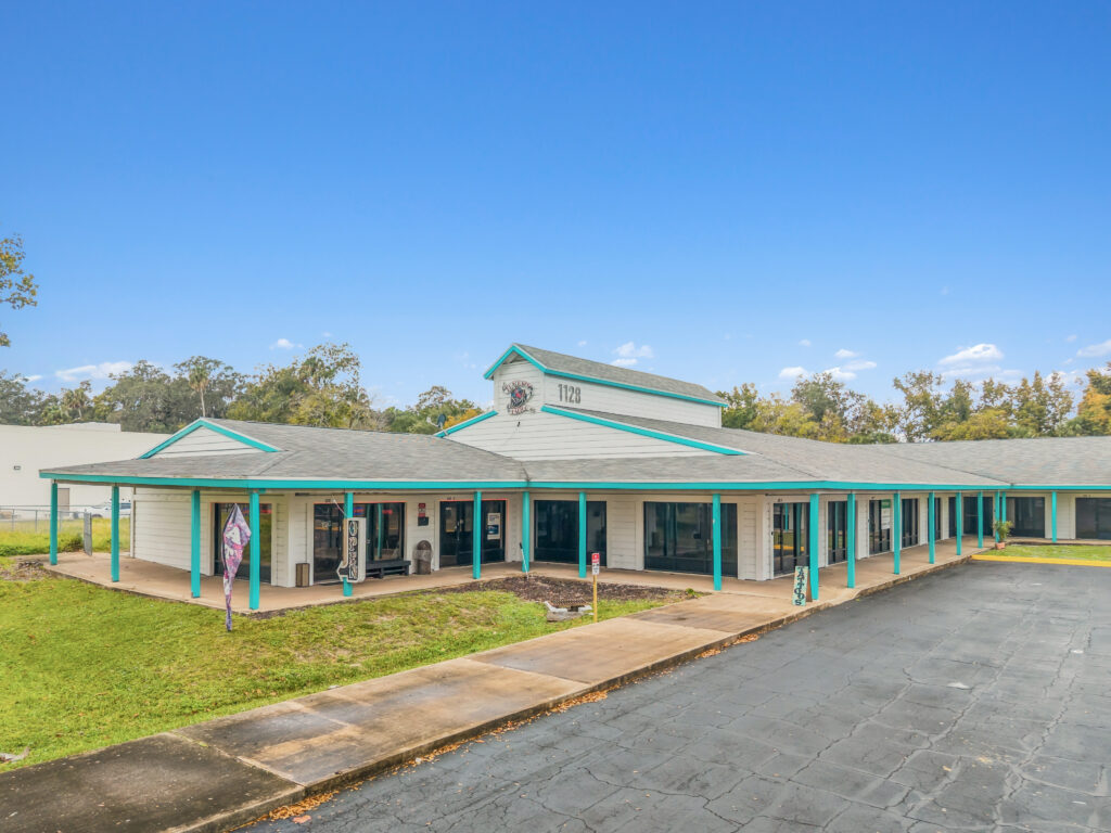 A view of the Village Plaza at 1128 Beville Rd, Daytona Beach, showcasing the modern architecture and surrounding landscape.