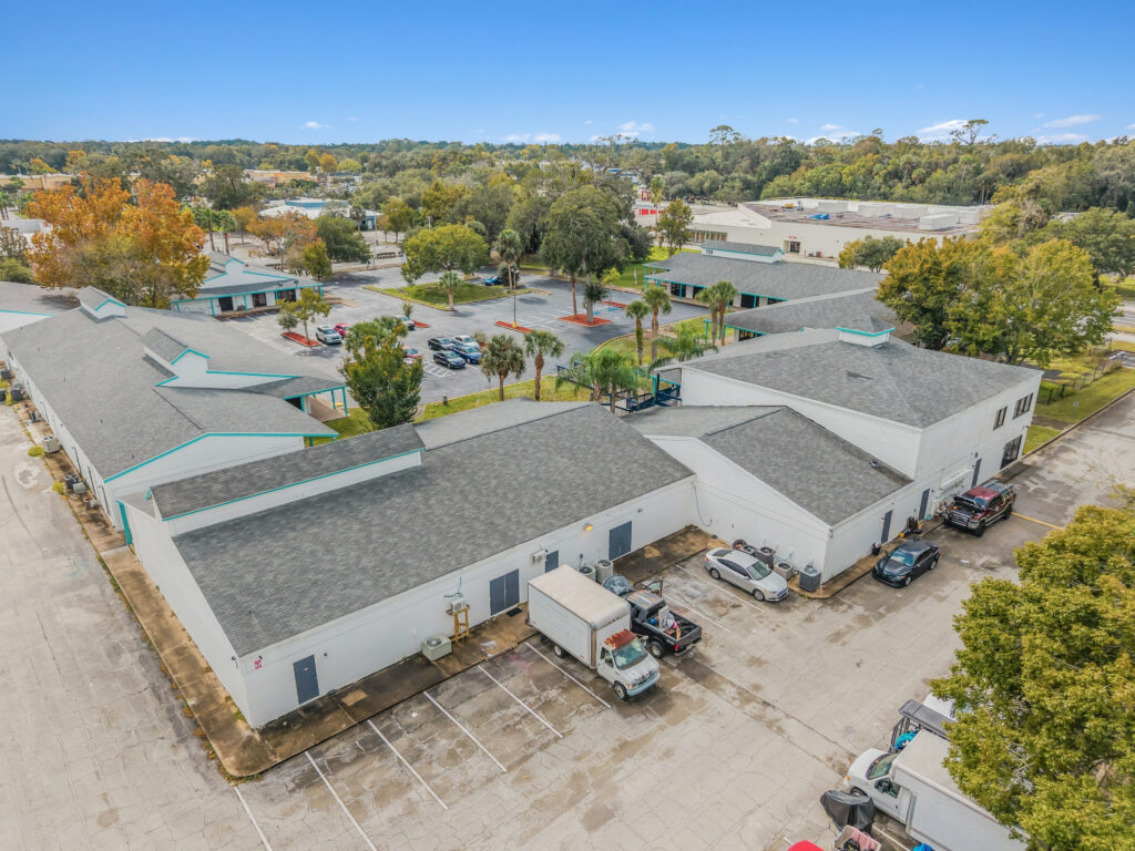 A spacious commercial property at 1128 Beville Rd, Daytona Beach, showcasing a modern exterior and ample parking.