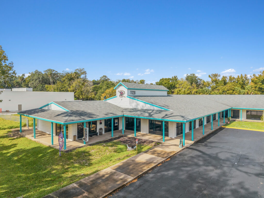 A modern commercial building at Village Plaza in Daytona Beach, showcasing its inviting entrance and landscaping.