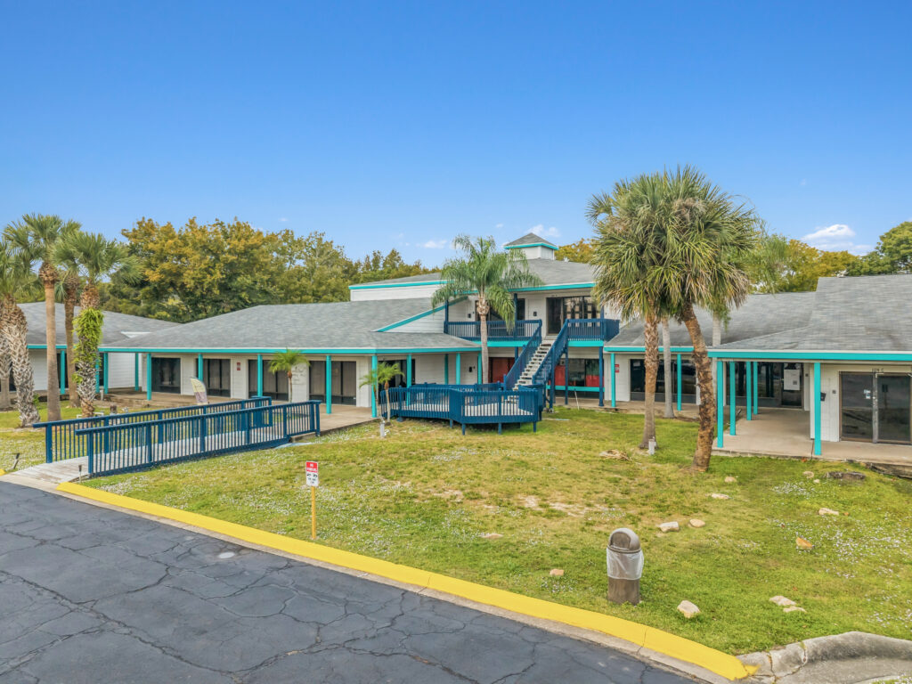 Exterior view of Village Plaza at 1128 Beville Rd, Daytona Beach, showcasing the building's architecture and surrounding area