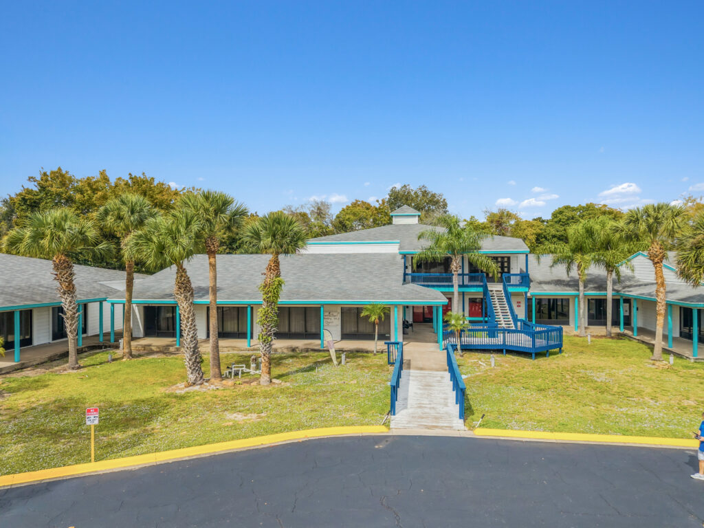 Exterior view of Village Plaza, showcasing the building's architecture and surrounding landscaping in Daytona Beach, FL.