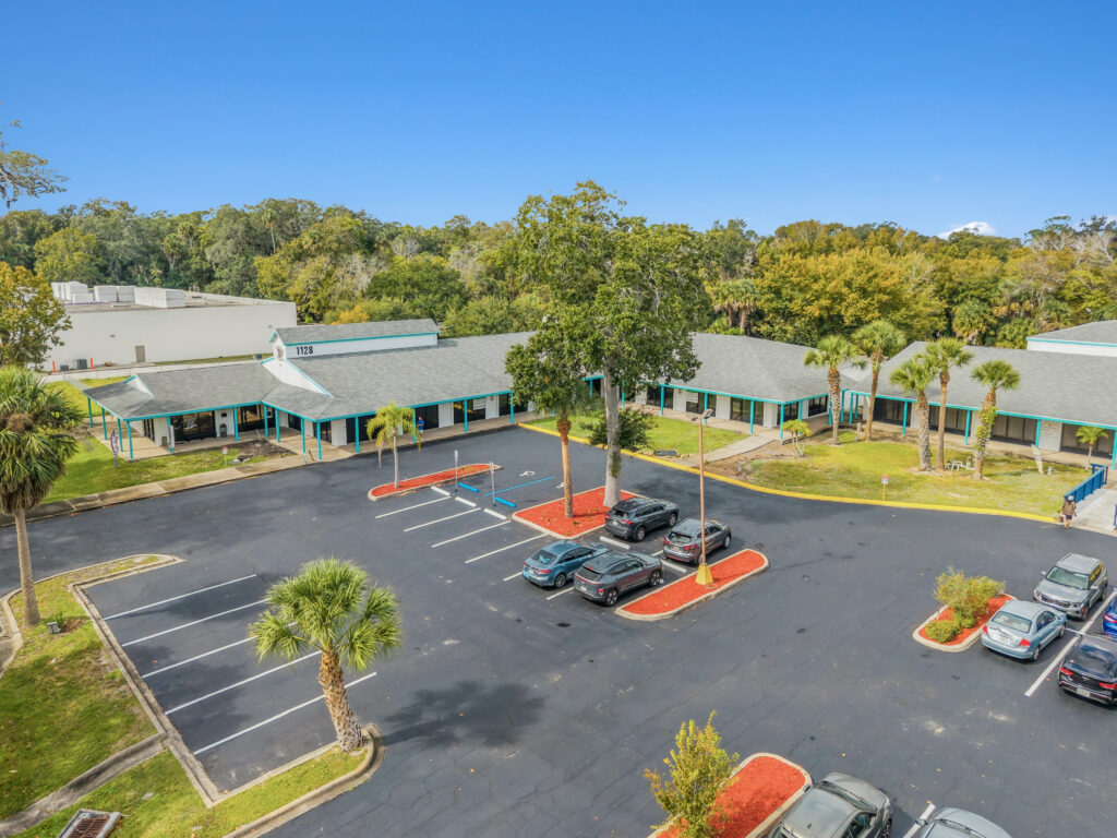 Exterior view of a commercial property at 1128 Beville Rd, Daytona Beach, showcasing its modern architecture and signage.