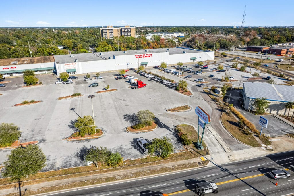 Exterior view of 5451 Norwood Ave, showcasing a retail space with a large parking area and signage.