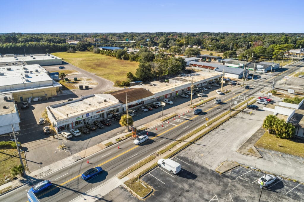 Exterior view of the Norwood Strip Mall in Jacksonville, showcasing storefronts and parking area.