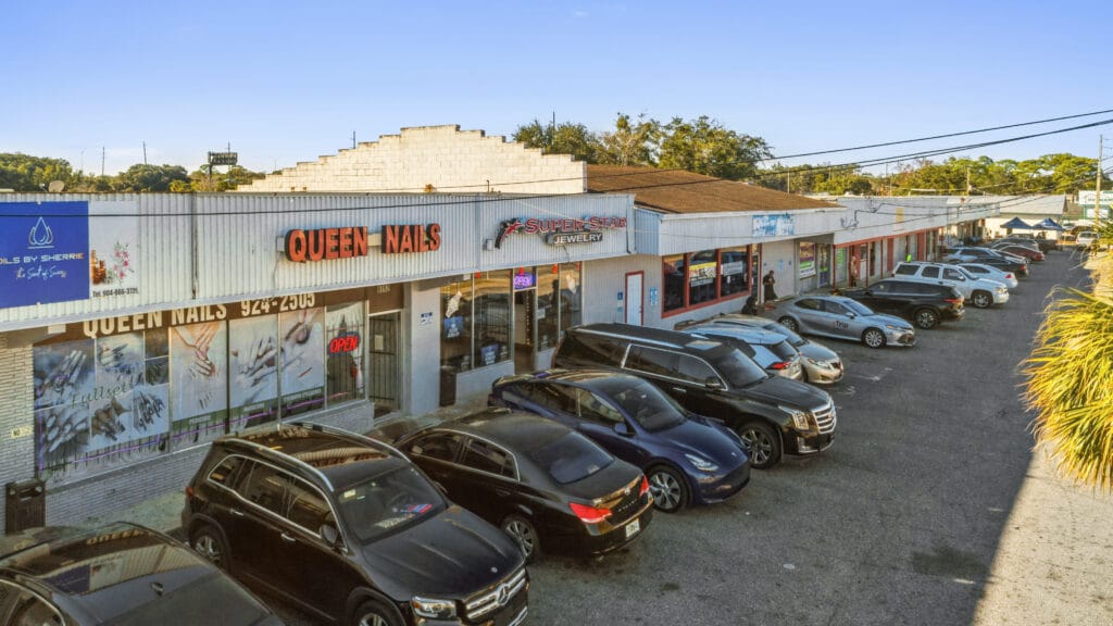 Exterior view of 5848 Norwood Ave, showcasing a retail strip mall with multiple storefronts and parking area.