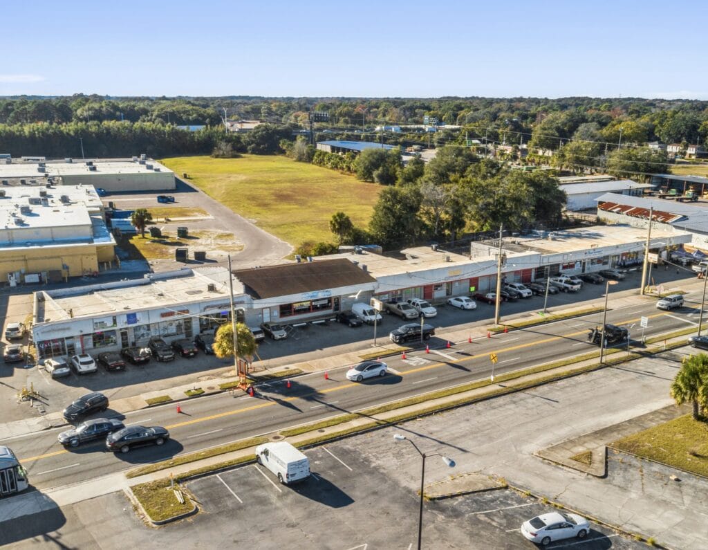 Exterior view of the Norwood Strip Mall, showcasing its storefronts and parking area, ideal for retail businesses.