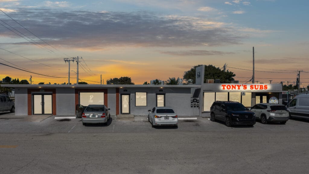 Exterior view of a modern residential building at 64 W 21st St, Riviera Beach, FL, showcasing its architecture and landscapin