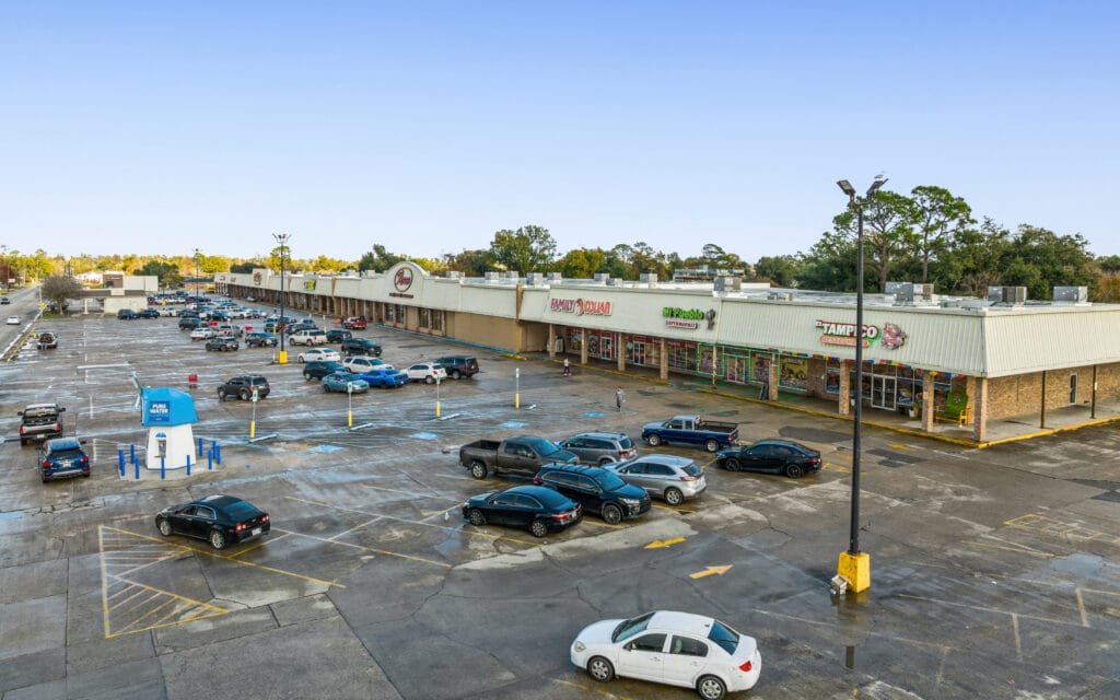 Exterior view of a large, two-story property at 1221 Grand Caillou Rd, Houma, LA, showcasing its architecture and surrounding