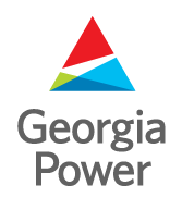 A vibrant sunset over the Georgia Power & Light facility, showcasing the power plant's structure against a colorful sky.