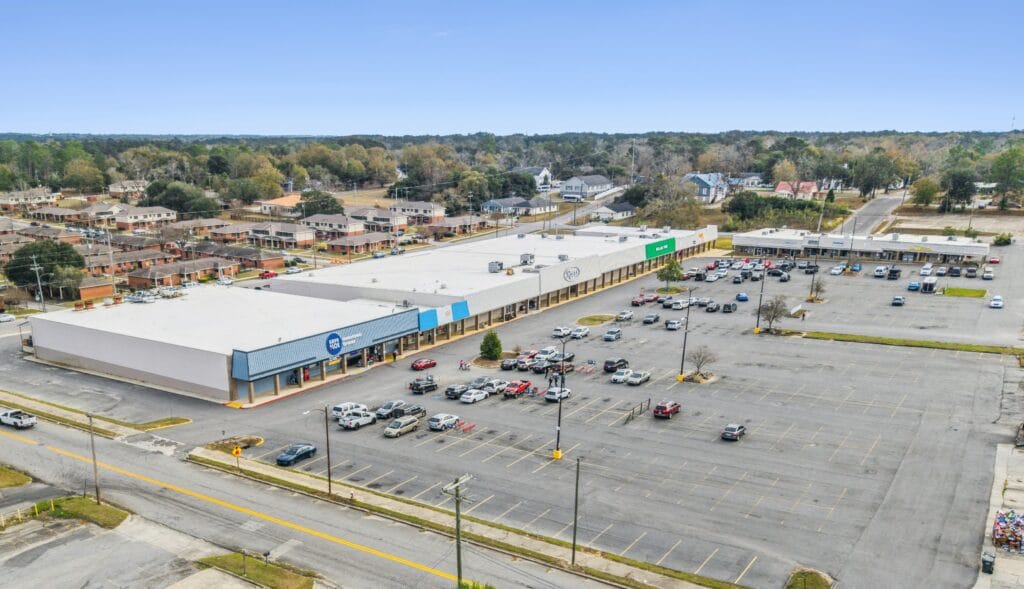 A modern commercial building with large glass windows and a welcoming entrance, showcasing Moultrie Plaza.