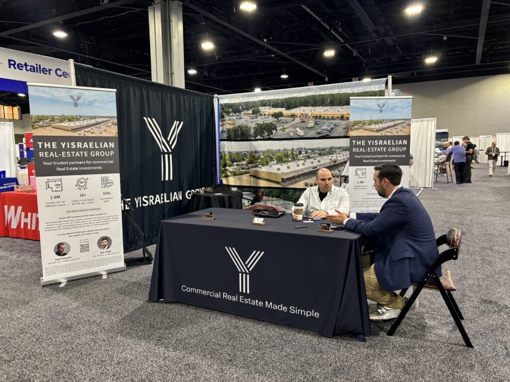 A conference scene at ICSC Atlanta, GA, showcasing attendees engaging in discussions and networking.